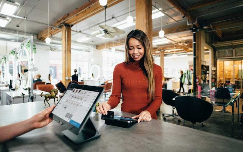An independent shop owner using a tablet behind the counter.