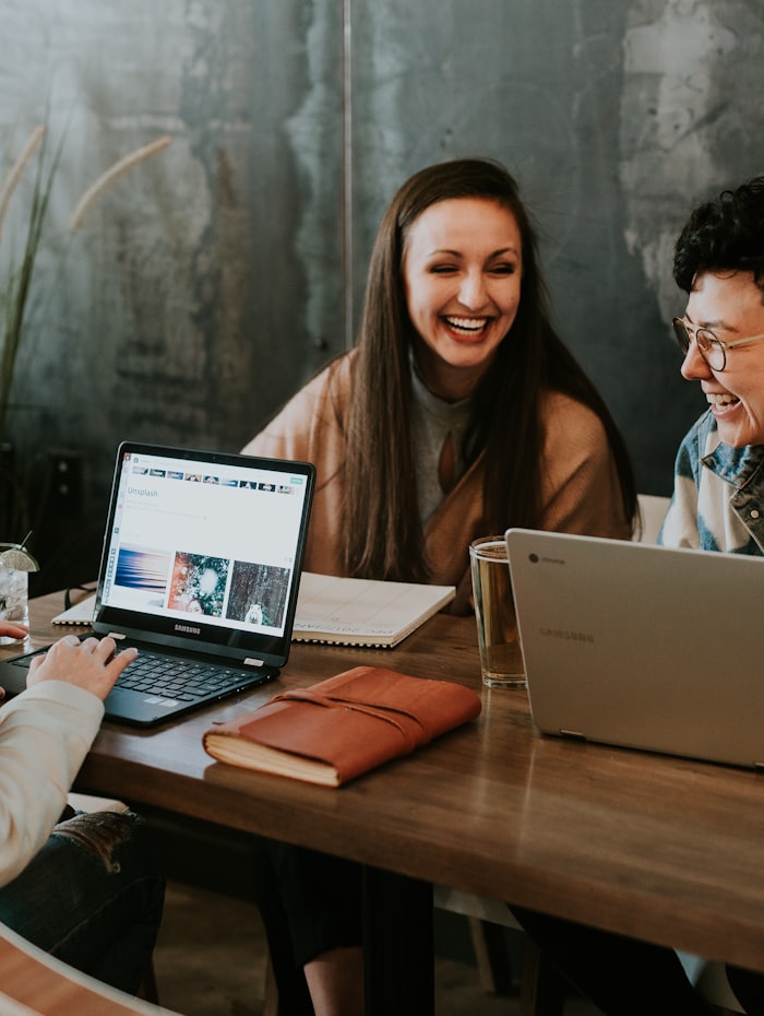 Three people planning a project together around their laptops.