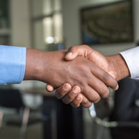Two people shaking hands after agreeing on work together.